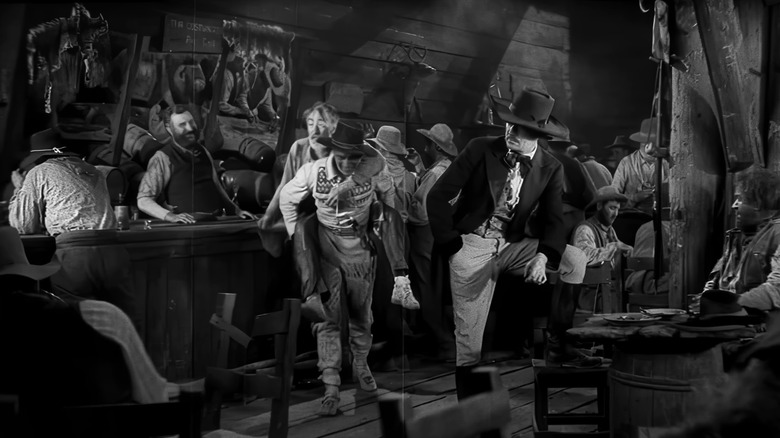 John Wayne as Breck Coleman carries Tully Marshall as Zeke on his back in The Big Trail