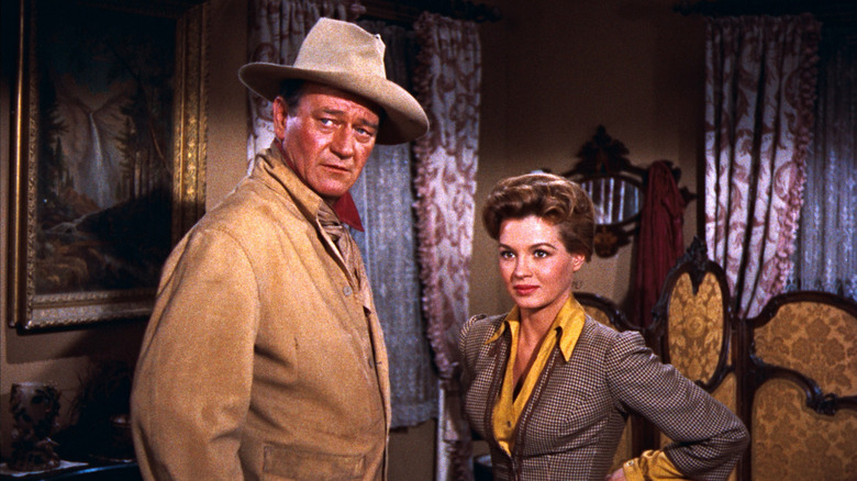 Sheriff Chance (John Wayne)and Feathers (Angie Dickinson) stand in a bedroom in Rio Bravo