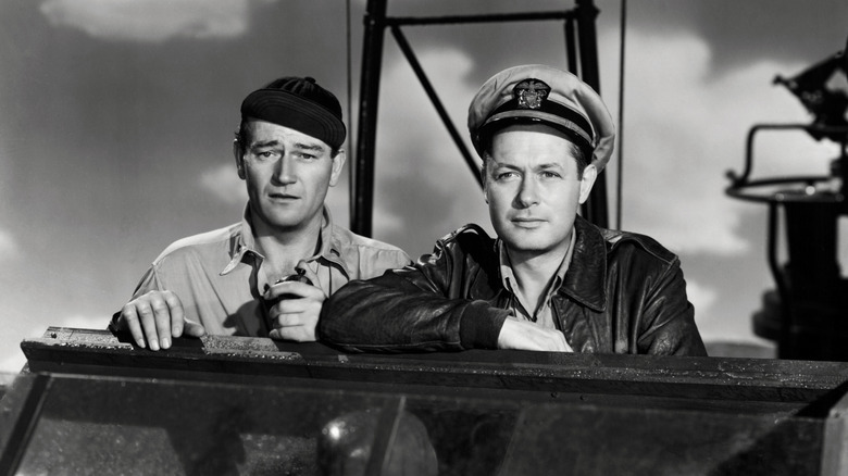 John Wayne as Lt. "Rusty Ryan" and Robert Montgomery as Lt. John Brickley standing together in They Were Expendable.