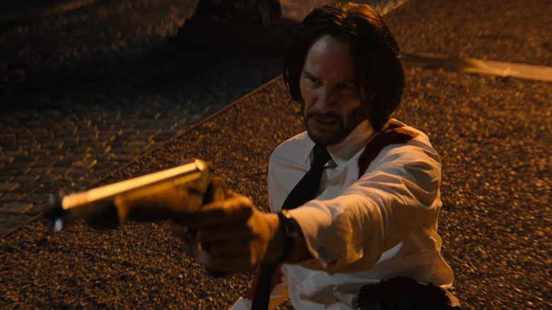 John Wick of Keanu Reeves shows a pistol lying on the ground in John Wick 4.Jpg