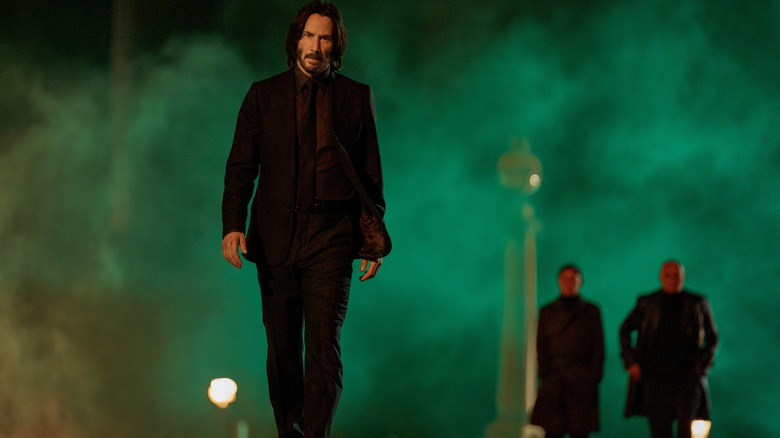 Keanu Reeves as John Wick walking down a foggy street in John Wick: Chapter 4