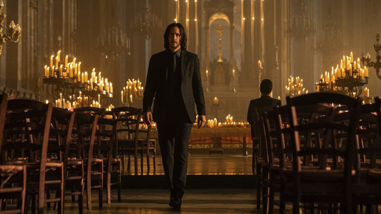 John Wick, wearing a black suit, walks out of a church in John Wick: Chapter 4