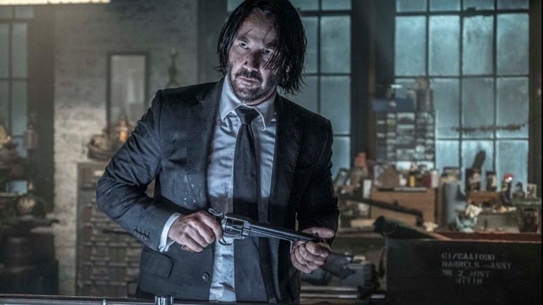 John Wick holds gun