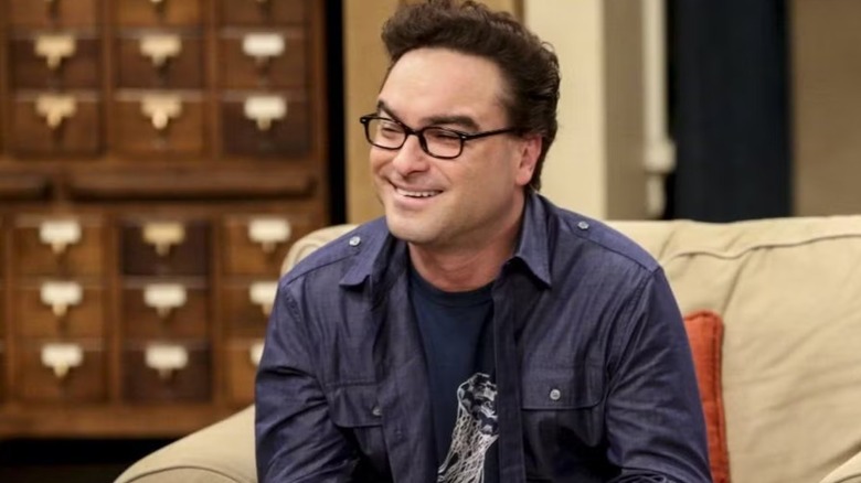 Leonard smiles and sits on an arms chair on the theory of the big explosion