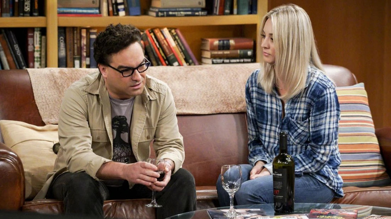 Penny and Leonard drinking wine and talking on the couch on The Big Bang Theory