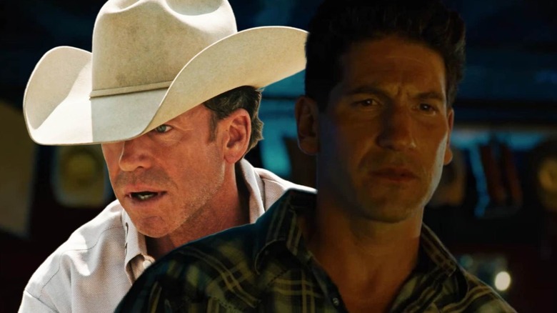 Taylor Sheridan wearing a hat behind Jon Bernthal in a checkered shirt