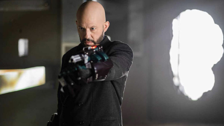 Jon Cryer como Lex Luthor blandiendo un arma en un episodio de Supergirl 