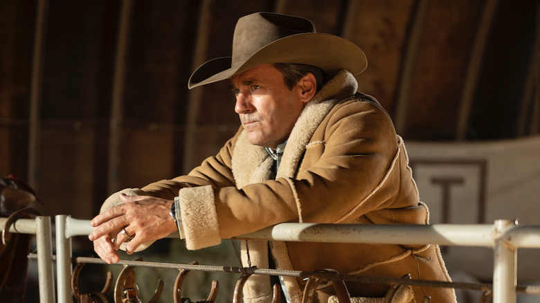 Roy in his shearling and a cowboy hat leaning over a gate in Fargo