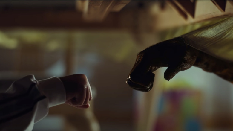 Someone fistbumping what looks to be an alien hand.