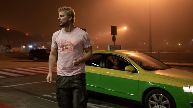 Lucas Reyes standing in front of a green car in the orange glow of a street light in Fight or Flight