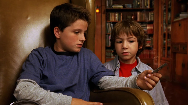 வால்டரும் டேனியும் ஜாதுரா: எ ஸ்பேஸ் அட்வென்ச்சரில் உள்ள தங்கள் வீட்டில் எரிந்த அட்டையைப் பார்க்கிறார்கள்