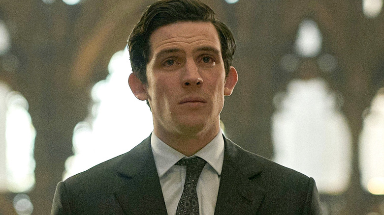 Josh O'Connor as Charles wearing a suit and standing alone in a church in The Crown