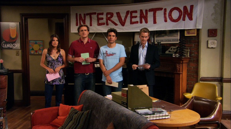 Robin, Marshal, Ted, and Barney in front of the intervention sign in How I Met Your Mother