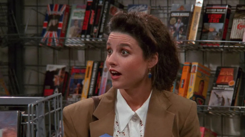Elaine looking surprised in a video rental store in Seinfeld
