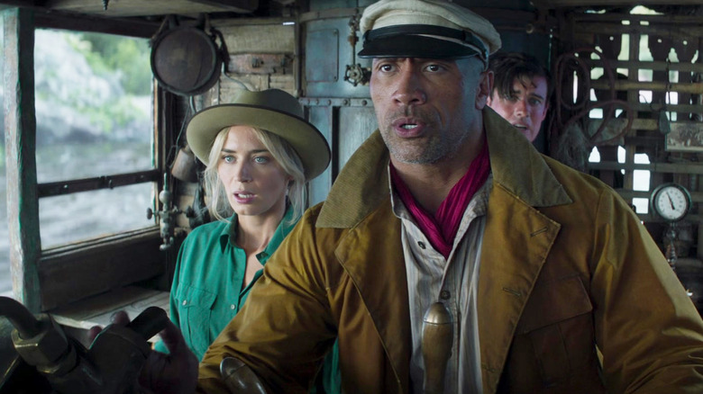 Emily Blunt as Lily Houghton, Dwayne Johnson as Frank Wolff, and Jack Whitehall as MacGregor Houghton looking scared on Frank's steamboat in Jungle Cruise
