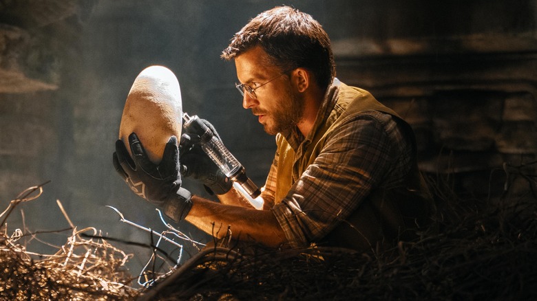 Dr. Henry Loomis (Jonathan Bailey) holds a dinosaur egg in Jurassic World Rebirth
