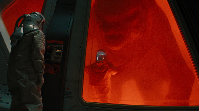 A mutant dinosaur stalking a scientists in a lab in Jurassic World Rebirth