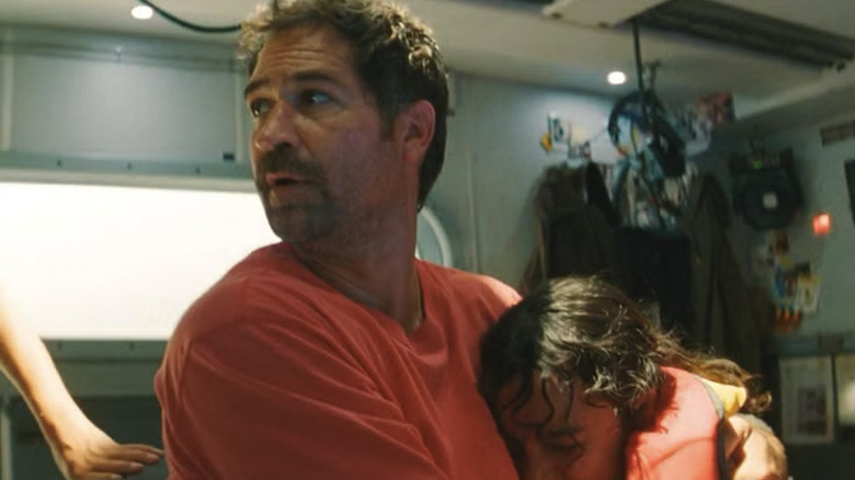 Reuben Delgado holding onto his daughter in Jurassic World Rebirth
