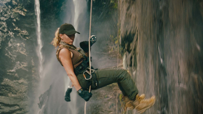 Zora repelling down a rock wall in Jurassic World: Rebirth