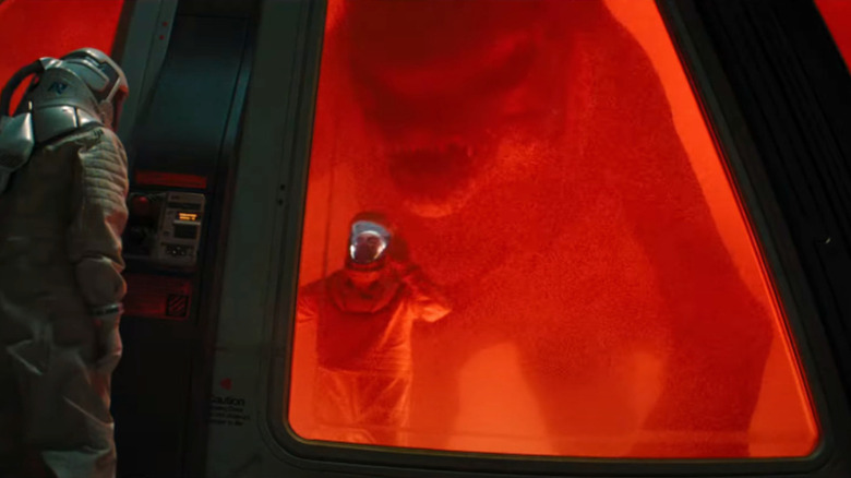 A technician trapped in a lab with a big monster behind him in Jurassic World: Rebirth