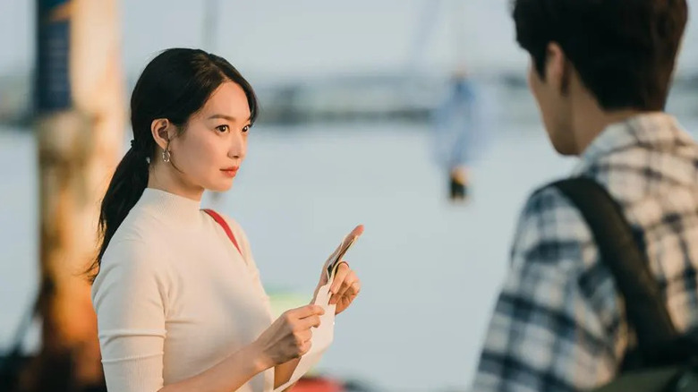 Yoon Hye-jin (Shin Min-a) glances up from a map by a dock in Hometown Cha-Cha-Cha