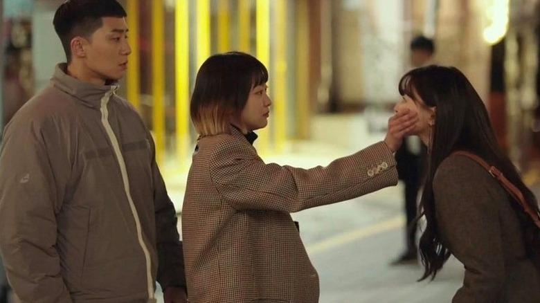 Park Sae-ro-yi (Park Seo-joon) warches Jo Yi-seo (Kim Da-mi) cover the mouth of Oh Soo-ah (Kwon Nara) in Itaewon Class
