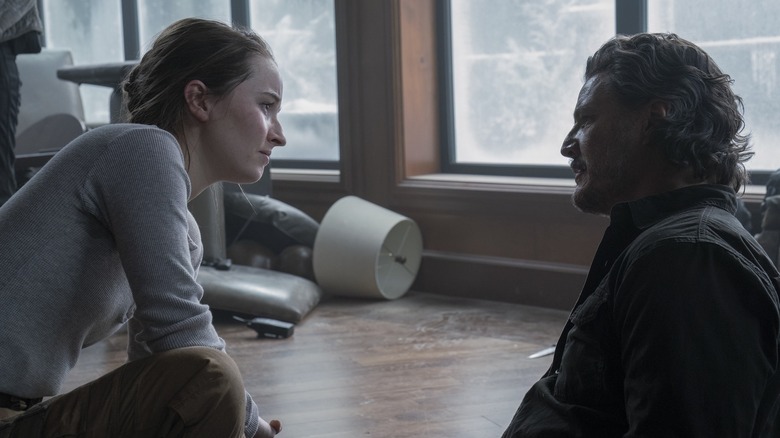 Abby crouched face to face with an injured Joel on The Last of Us