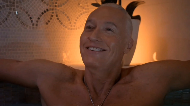 Terry Silver smiling in a hot tub in Cobra Kai