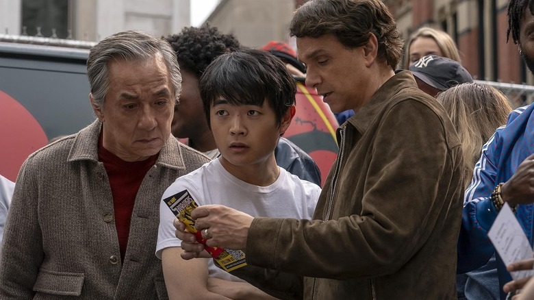 Li Fong standing in the middle of Mr. Han and Daniel LaRusso