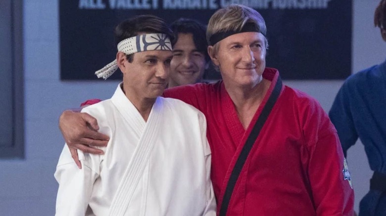 Daniel LaRusso and Johnny Lawrence standing side by side on Cobra Kai