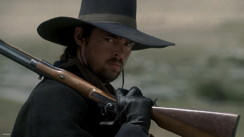 Karl Urban's Woodrow F. Call looks off to his right as he holds a rifle in Comanche Moon