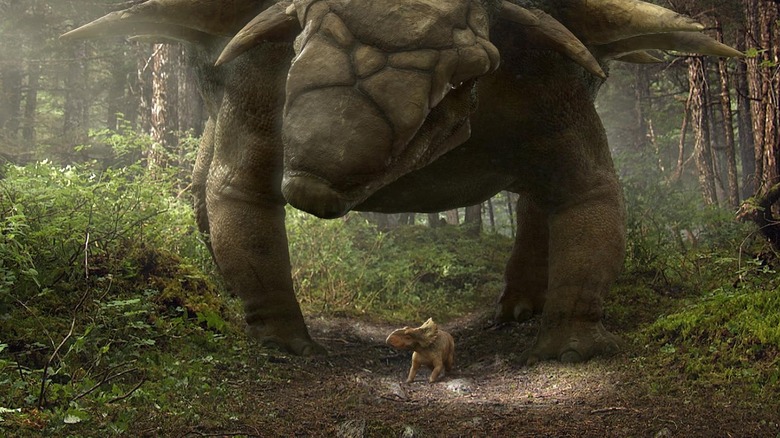 Justin Long as Patchi standing beneath an ankylosaurus in Walking with Dinosaurs (2013)