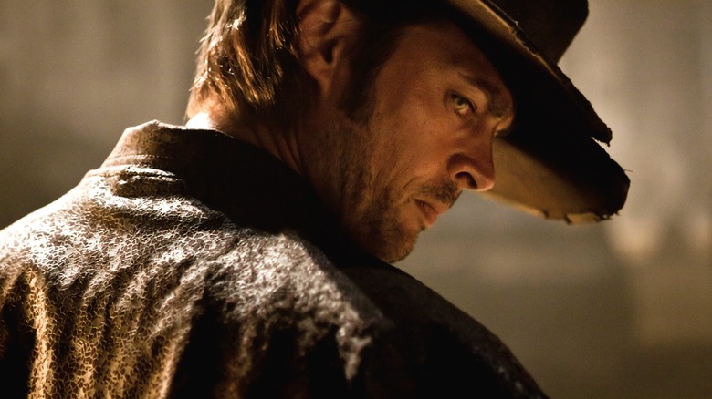Karl Urban's Black Hat looks back at someone offscreen in Priest