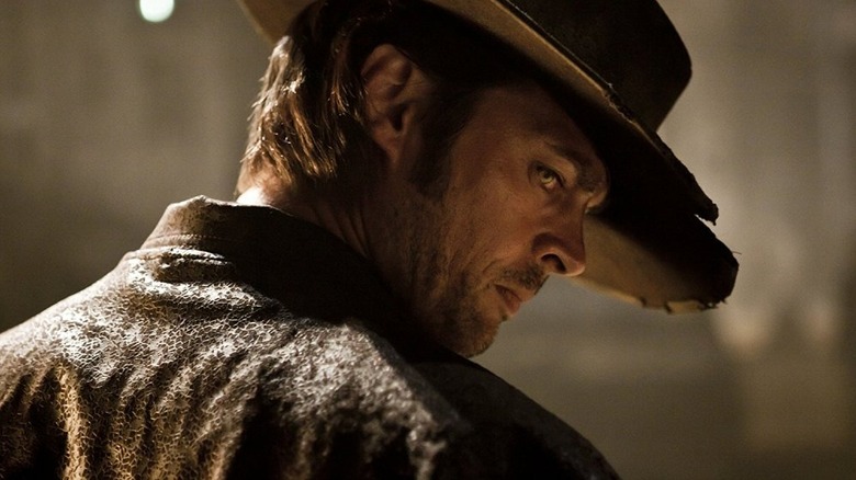 Karl Urban as Black Hat in Priest, looking back over his shoulder wearing his signature black hat