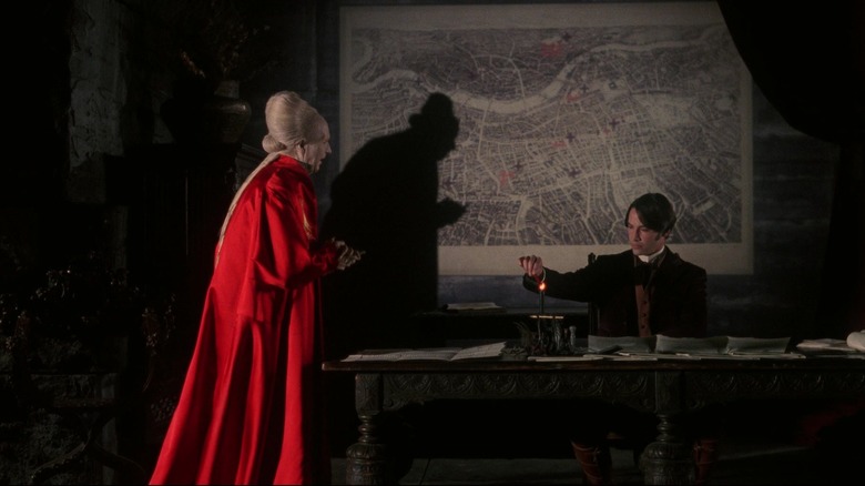 Gary Oldman's Count Dracula walks toward Keanu Reeves' Jonathan Harker as he sits at a table in Bram Stoker's Dracula