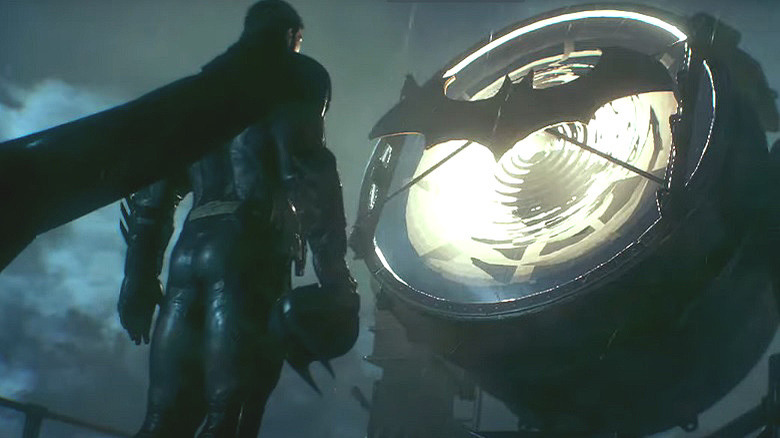 Batman stands in front of the Bat-Signal
