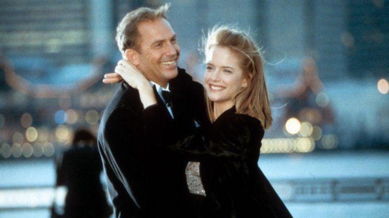 Kevin Costner como Billy Chappelle y Kelly Preston como Gene Aubrey se abrazan en Por amor al juego