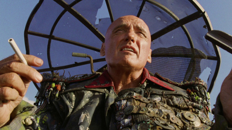 Dennis Hopper as The Deacon holding a cigarette in Waterworld