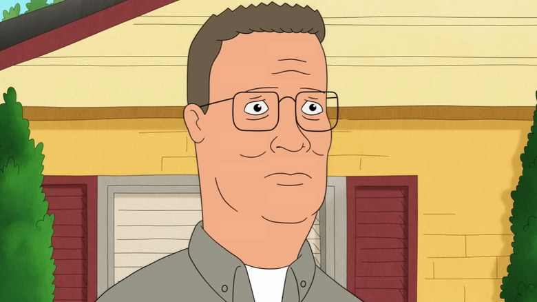 Hank Hill standing in front of his house and looking sort of overwhelmed