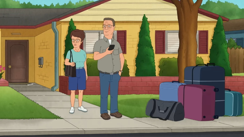 Peggy and Hank Hill with luggage in front of their house in the King of the Hill revival
