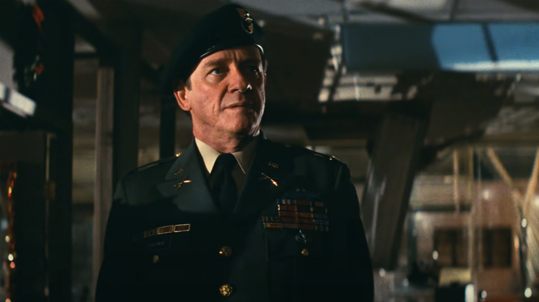 Richard Crenna's Colonel Samuel R. Trautman stands in a dark room in First Blood