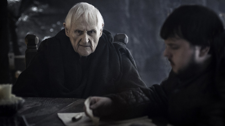 Peter Vaughan as Aemon Targaryen seated at a table next to John Bradley as Samwell Tarly in Game of Thrones