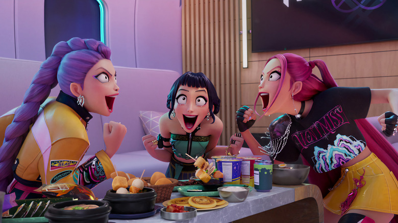 Rumi, Zoey, and Mira around a table of food with excited looks on their faces in KPop Demon Hunters