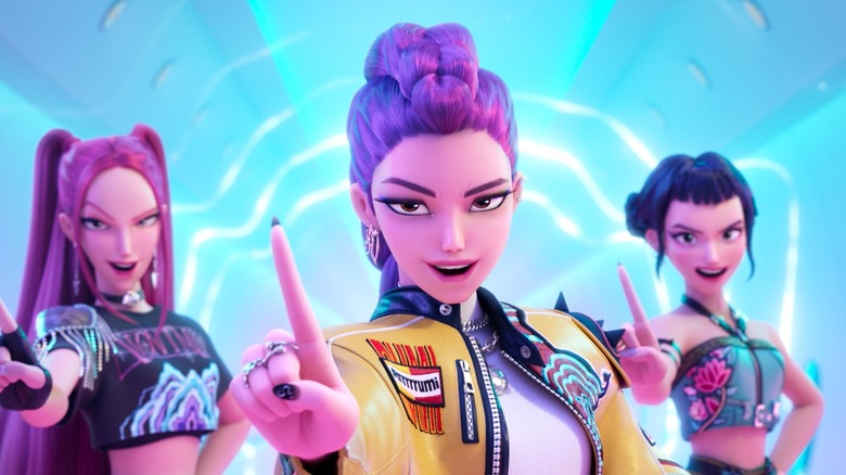 Arden Cho's Rumi, May Hong's Mira, and Ji-young Yoo's Zoey confidently holding up their fingers in KPop Demon Hunters
