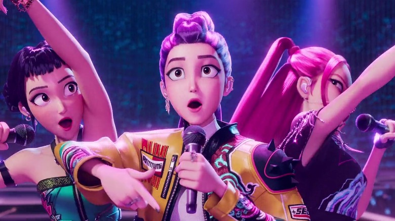 Arden Cho's Rumi poses on stage flanked by May Hong's Mira and Ji-young Yoo's Zoey in KPop Demon Hunters