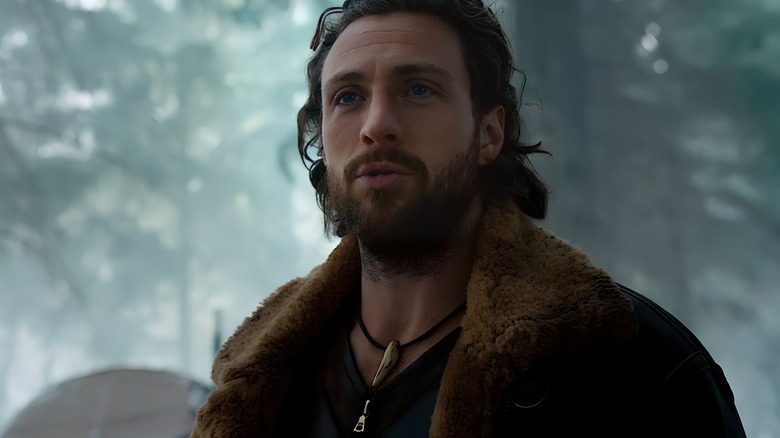 Aaron Taylor-Johnson as Kraven standing in the woods in Kraven the Hunter