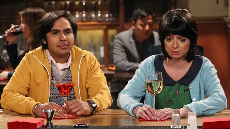 Raj and Lucy looking confused at a bar with their drinks on The Big Bang Theory
