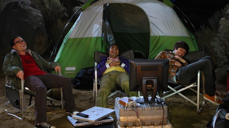 Leonard, Raj, and Howard laughing at a campsite in The Big Bang Theory