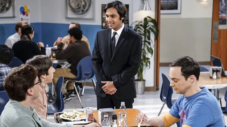 Raj in a suit talking to the guys in the cafeteria in The Big Bang Theory