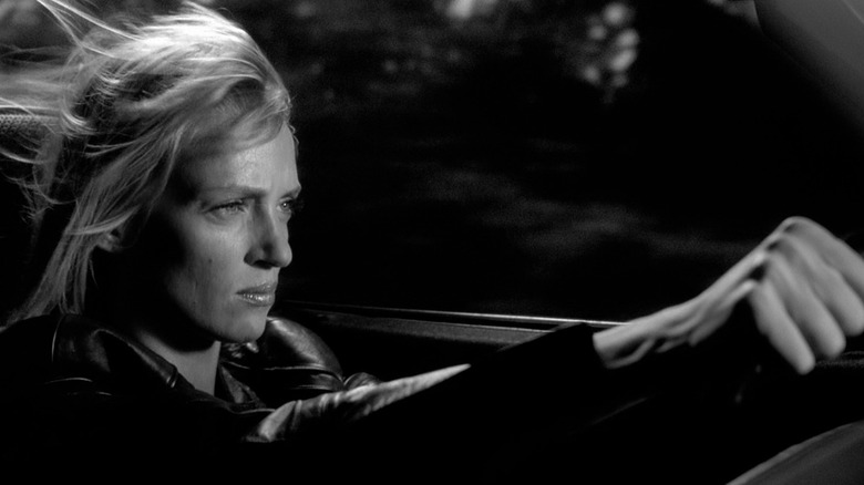 Uma Thurman as Beatrix Kiddo driving a car in black and white in Kill Bill Vol. 2